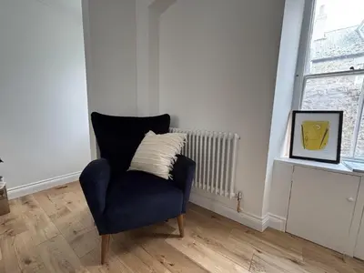a blue chair sitting in a room with a window at 9 Mount Pleasant in St Ives