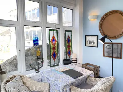 a room with a table with stained glass windows at Step n Sea - moments from the town centre and sea in St Ives