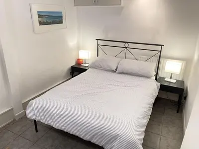 a bedroom with a bed with two night stands and two lamps at Step n Sea - moments from the town centre and sea in St Ives