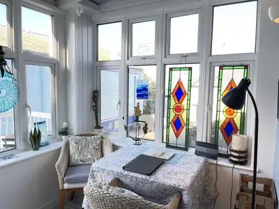 a room with a table with stained glass windows at Step n Sea - moments from the town centre and sea in St Ives