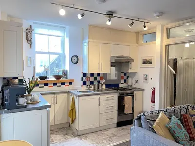 a kitchen with white cabinets and a stove top oven at Step n Sea - moments from the town centre and sea in St Ives