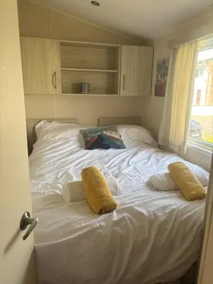 a large white bed in a room with a window at Newquay Bay - 3-Bed Caravan - Sleeps 6 in Newquay