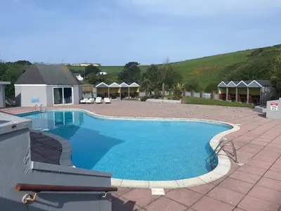 a large swimming pool in a yard with a patio at Newquay Bay - 3-Bed Caravan - Sleeps 6 in Newquay