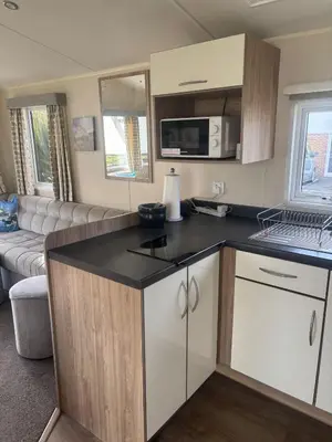 a kitchen with a counter top and a living room at Newquay Bay - 3-Bed Caravan - Sleeps 6 in Newquay