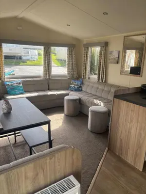 a living room with a couch and a table at Newquay Bay - 3-Bed Caravan - Sleeps 6 in Newquay