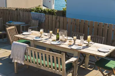 a wooden table with candles on it on a patio at Holiday home with incredible sea views in Mevagissey
