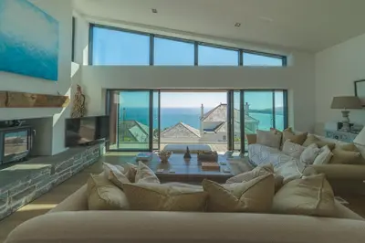 a living room with a large couch and a fireplace at Holiday home with incredible sea views in Mevagissey