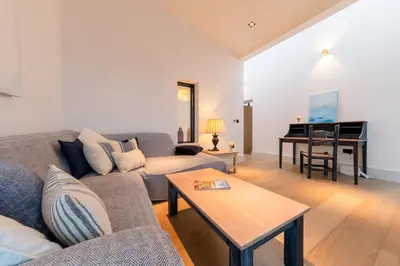 a living room with a couch and a piano at Holiday home with incredible sea views in Mevagissey