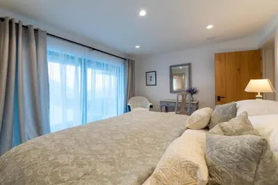 a bedroom with a large bed and a large window at Holiday home with incredible sea views in Mevagissey