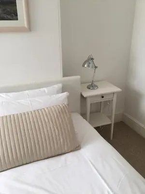 a bedroom with a bed and a table with a lamp at Ten Ocean View in St Ives