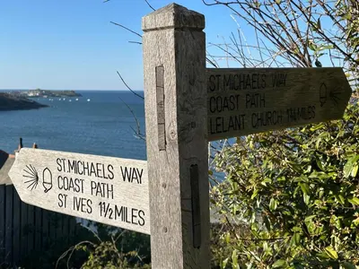 a sign on a wooden post next to the water at Luxury, Tranquillity Near Beach in Carbis Bay