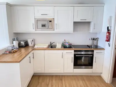 a kitchen with white cabinets and a counter top at 36 Carrack Widden in St Ives