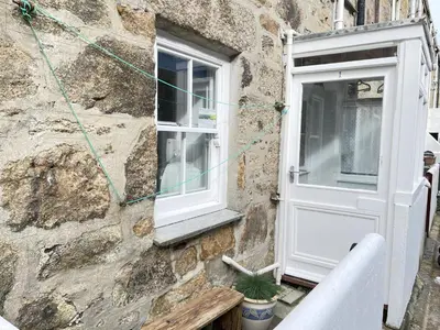 a door and a window in a stone building at Surfers Nest a modern fisherman lodge in St Ives