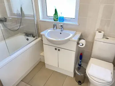 a bathroom with a sink and a toilet and a window at 4 Crusoes - beachside apartment in St Ives