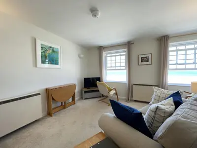 a living room with a couch and a tv at 4 Crusoes - beachside apartment in St Ives