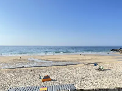 a beach with an orange tent on the sand at 4 Crusoes - beachside apartment in St Ives