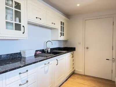 a kitchen with white cabinets and a sink at 4 Sunday School Court in St Ives