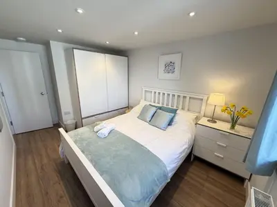 a bedroom with a large white bed with blue pillows at 4 Sunday School Court in St Ives