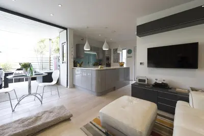a kitchen and living room with a couch and a table at Two Bare Feet in Truro