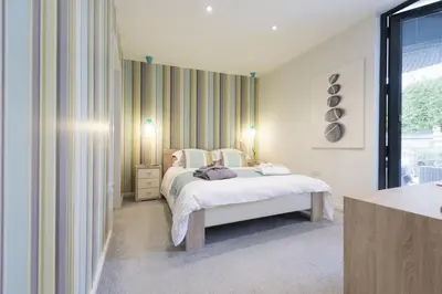a white bedroom with a bed and a window at Two Bare Feet in Truro