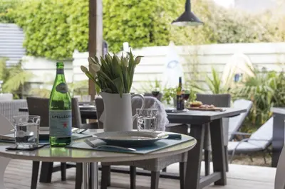 a table with a bottle of wine on a patio at Two Bare Feet in Truro