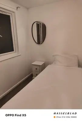 a bedroom with a white bed and a mirror at 52 strawberry in Hayle