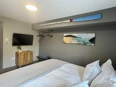 a bedroom with a bed and a flat screen tv at Uno Moor Side - 4 Bed, 2 Bath, Garden, sleeps 8 - Parking in Carbis Bay
