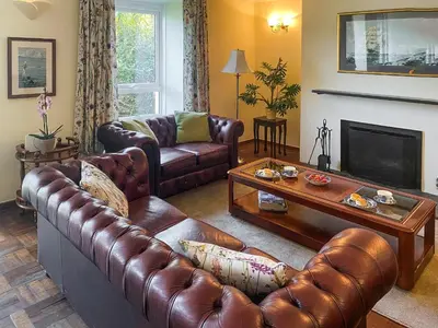 a living room with leather furniture and a fireplace at Riverside in Truro