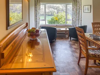 a dining room with a glass table with a bowl of fruit on it at Riverside in Truro