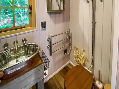 a bathroom with a sink and a wooden toilet at The Goose Nest in Cardinham