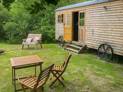a picnic table and chairs next to a cabin at The Goose Nest in Cardinham