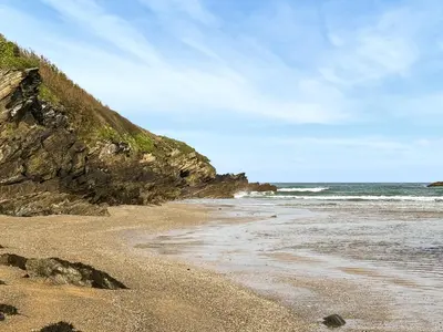 a sandy beach with the ocean in the background at Liwus in Newquay