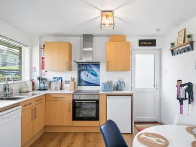 a kitchen with wooden cabinets and a counter top at Liwus in Newquay