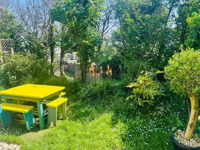 a yellow table and two yellow benches in a garden at Cassajossy in Bude