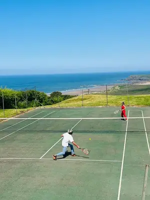 two people playing tennis on a tennis court at Cassajossy in Bude