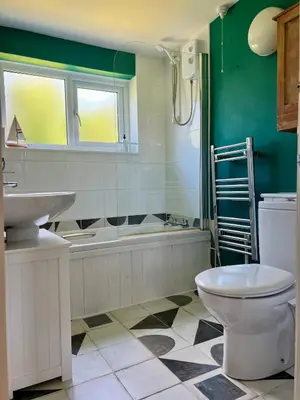 a bathroom with a toilet and a sink and a tub at Cassajossy in Bude