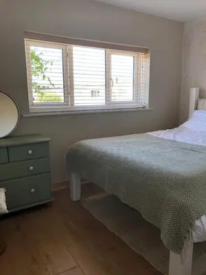 a bedroom with a bed and a mirror and a window at Cassajossy in Bude