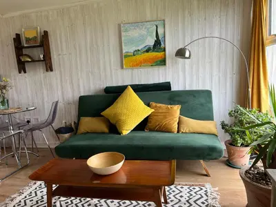 a living room with a green couch and a table at Cassajossy in Bude