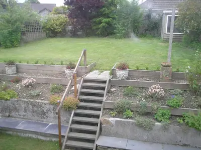 a garden with stairs and potted plants in a yard at Cottage On The Square in Camelford