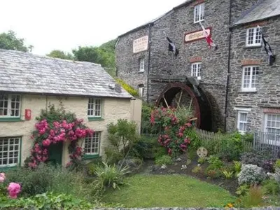 an old stone building with flowers in front of it at Cottage On The Square in Camelford