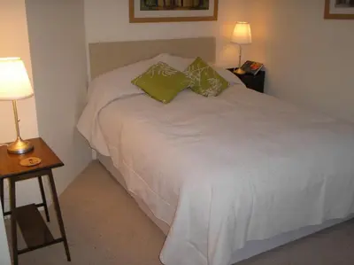 a bedroom with a white bed with two green pillows at Cottage On The Square in Camelford