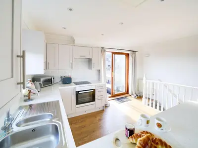 a kitchen with white cabinets and a counter top at Wenlock in Polzeath