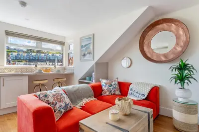 a living room with a red couch and a table at High Tide Bedford Rd Boutiques in St Ives