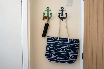 a tote bag hanging on a wall with hooks at High Tide Bedford Rd Boutiques in St Ives