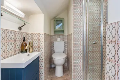 a bathroom with a toilet and a glass shower at High Tide Bedford Rd Boutiques in St Ives