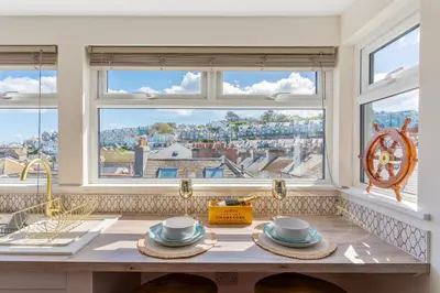 a kitchen with a counter with two cups and a window at High Tide Bedford Rd Boutiques in St Ives
