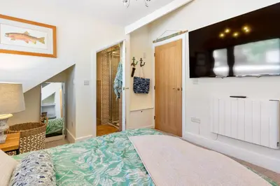 a bedroom with a bed and a tv on the wall at High Tide Bedford Rd Boutiques in St Ives