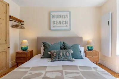 a bedroom with a bed with blue pillows at Low Tide Bedford Rd Boutiques in St Ives