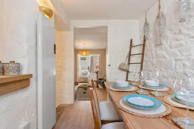 a dining room with a wooden table with blue plates at Low Tide Bedford Rd Boutiques in St Ives