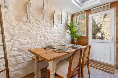 a dining room with a wooden table and chairs at Low Tide Bedford Rd Boutiques in St Ives